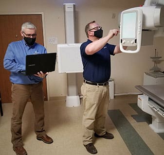 two men working with medical imaging equipment